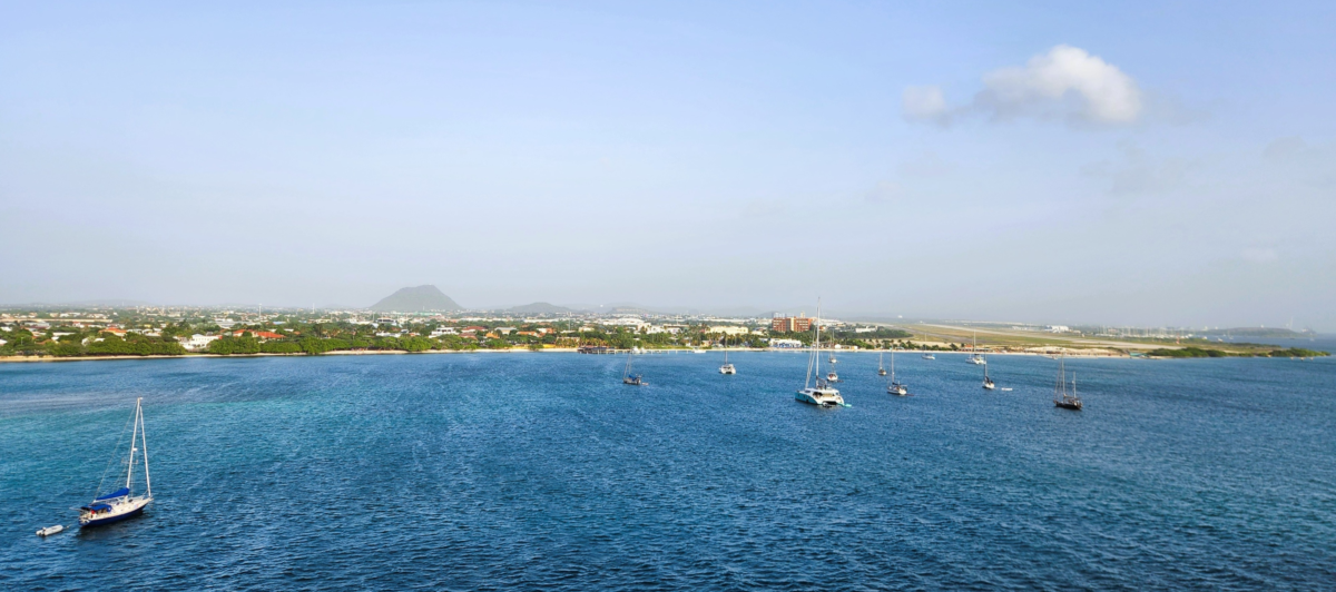 Aruba 3.1 - Dohrn Travels Coastal view of Aruba with clear blue water and anchored boats – popular Caribbean cruise destination