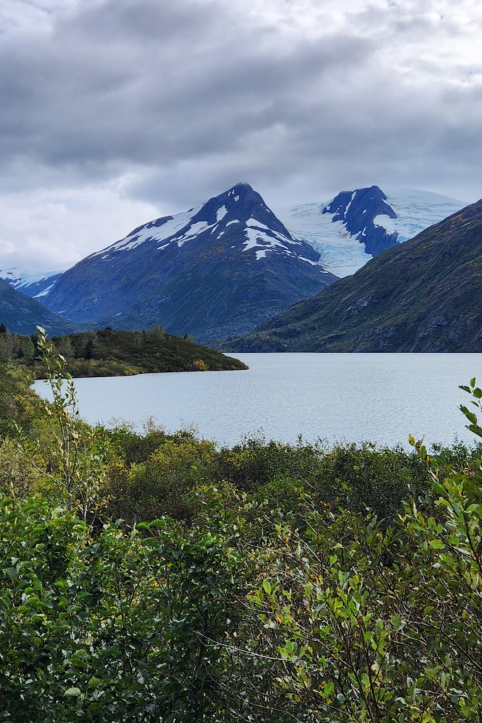 Portage Glacier and Lake – Scenic View near Whittier, Alaska - Dohrn Travels Portage Glacier and lake view surrounded by mountains and greenery near Whittier, Alaska.