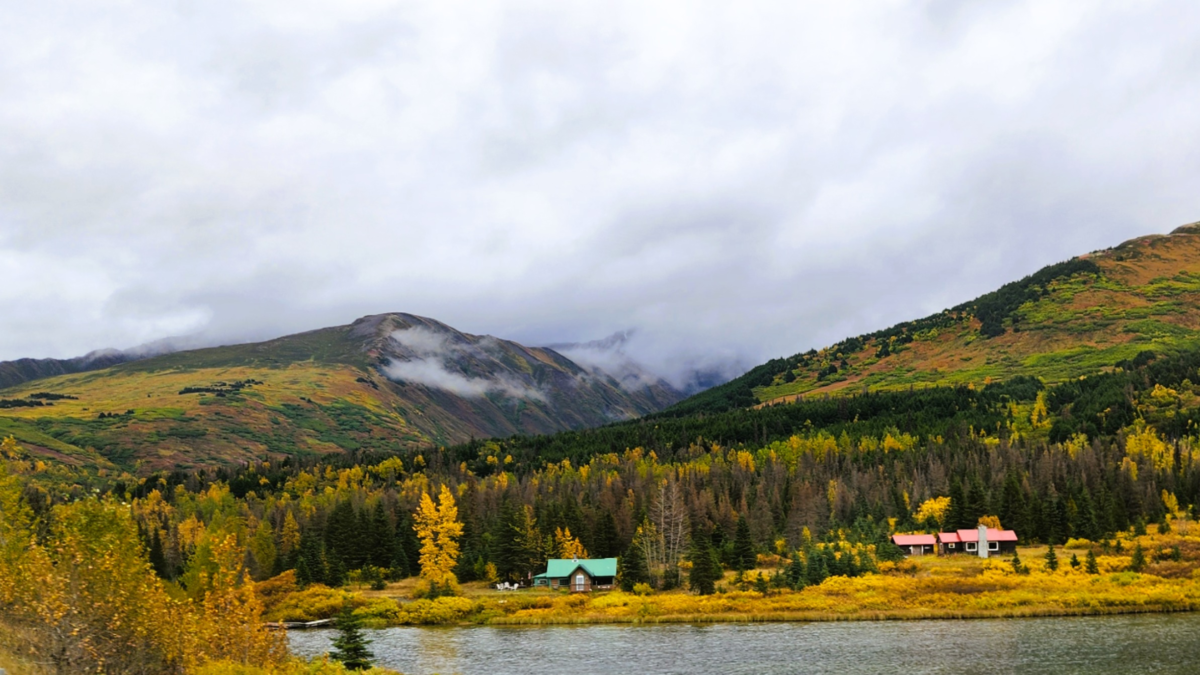 Cabins by the Lake on Seward Highway – Autumn Scenery in Alaska - Dohrn Travels Cabins by a lake surrounded by fall colors and mountain views along the Seward Highway in Alaska.