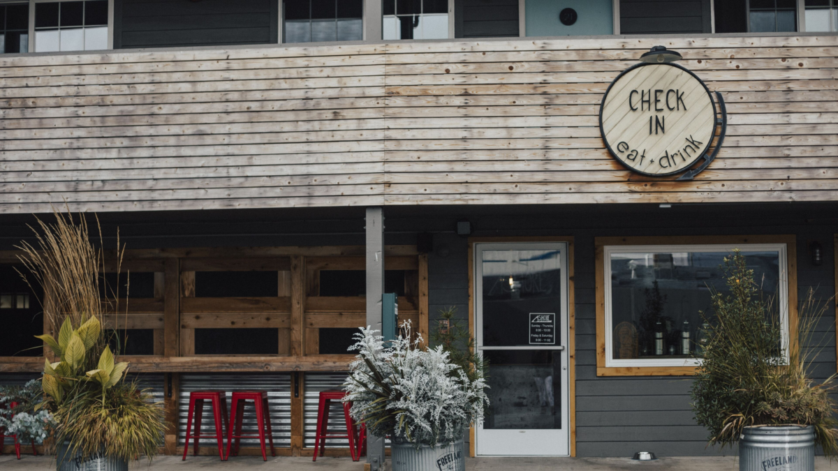 Front entrance of Ashore Hotel in Seaside Oregon with rustic wood design and cozy outdoor seating