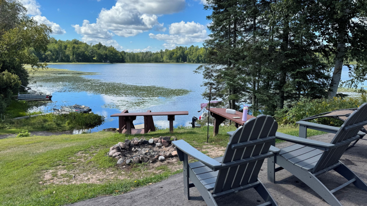 Lakeside firepit area with Adirondack chairs overlooking Island Lake near Winter, Wisconsin. Winter Wisconsin Cabin Rentals