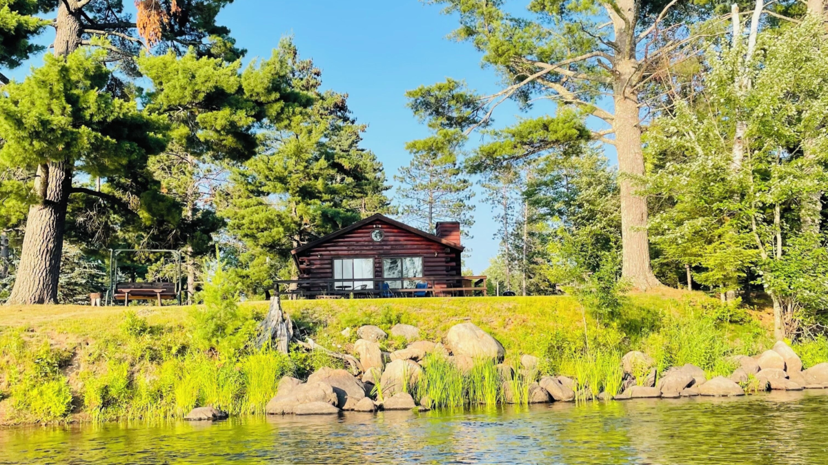 Riverfront cabin surrounded by tall pines at Eagle Lodge near Blaisdell Lake and the Chippewa River in Winter, Wisconsin