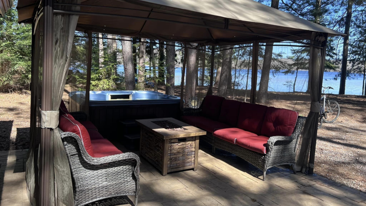 Outdoor seating area with hot tub and fire table at a luxury cabin on Lake Winter in Northern Wisconsin