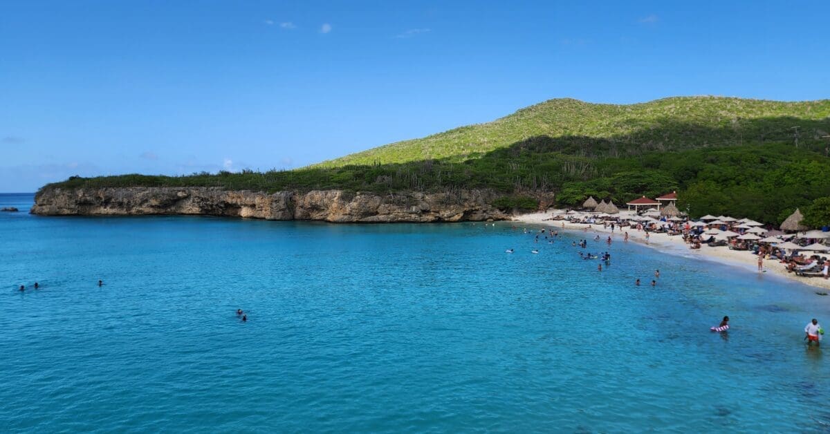 Swimming Area at Grote Knip Beach Curaçao - Dohrn Travels Wide view of Grote Knip Beach Curaçao showing swimmers and calm turquoise water