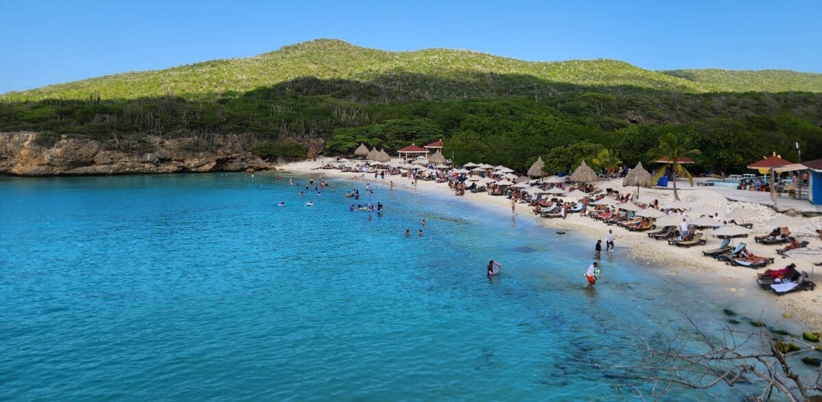 Grote Knip Beach Curaçao Panoramic View - Dohrn Travels Panoramic view of Grote Knip Beach in Curaçao with turquoise water and beach umbrellas